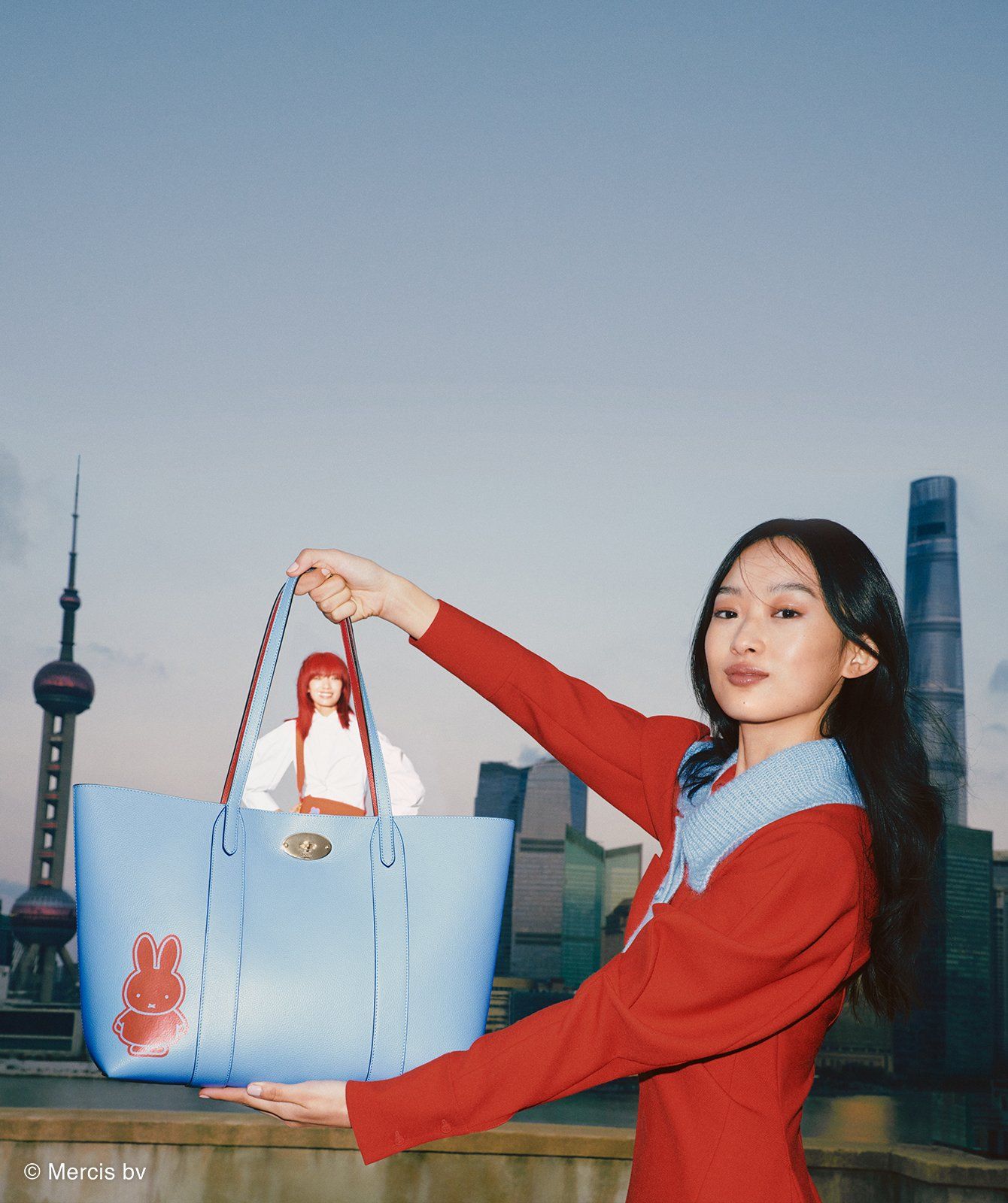 Model holding Mulberry Bayswater tote bag in blue with red Miffy print